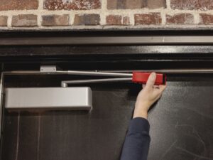 A man installing the sleeve on a steel door